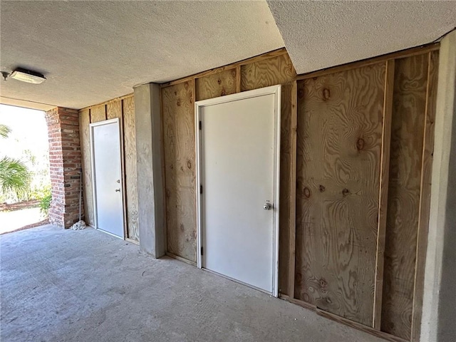 91 Screven St, Darien, GA 31305 - miscellaneous room featuring a textured ceiling, carpet, and wood walls
