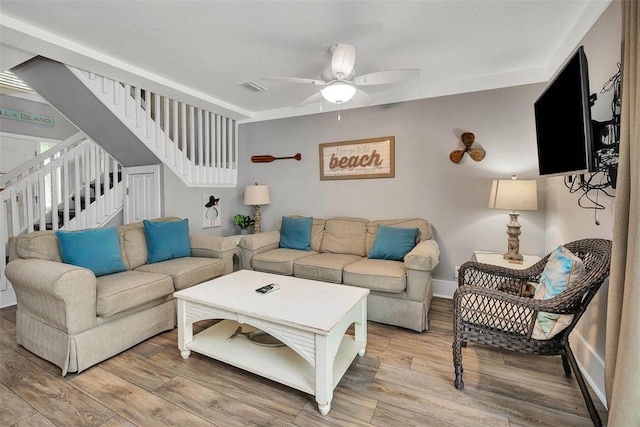 1175 N Beachview Dr Unit 414, Jekyll Island, GA 31527 - living room with stairway, ceiling fan, light wood-style floors, and baseboards