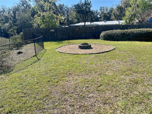 view of yard featuring a fire pit and fence