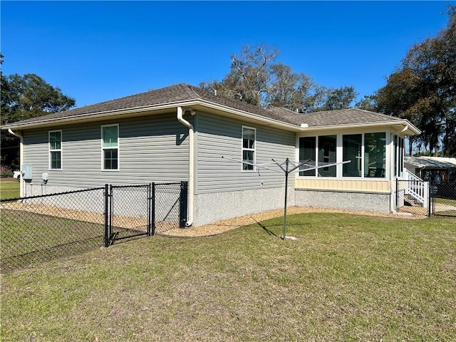 view of side of property featuring a gate, a yard, fence, and a sunroom