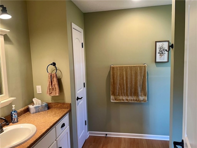 bathroom featuring vanity, wood finished floors, and baseboards