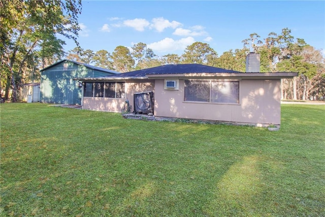 rear view of property featuring a lawn and a sunroom