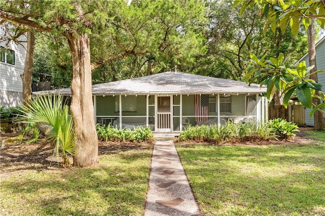 view of front of house featuring a front lawn and a sunroom