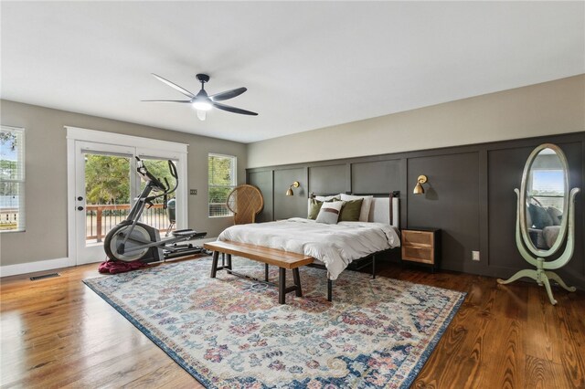 208 Bishop Cir, Saint Marys, GA 31558 - bedroom featuring access to exterior, multiple windows, wood finished floors, a decorative wall, and ceiling fan