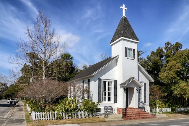 208 Bishop Cir, Saint Marys, GA 31558 - view of home's exterior with fence, a shingled roof, and brick siding