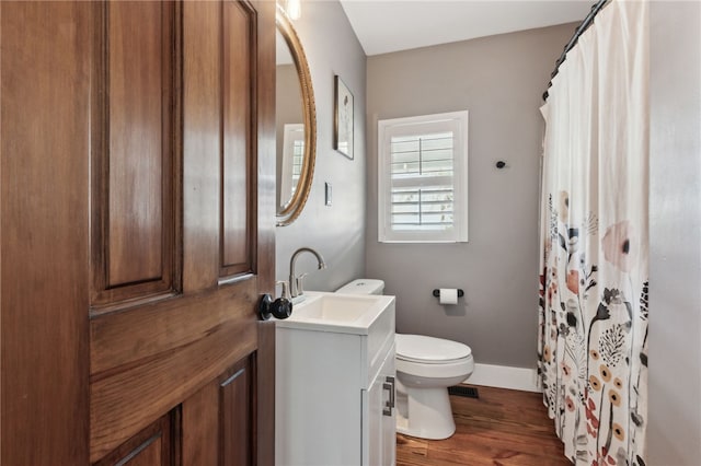 208 Bishop Cir, Saint Marys, GA 31558 - bathroom with toilet, wood finished floors, vanity, baseboards, and a shower with shower curtain