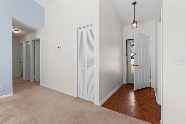 entrance foyer featuring dark parquet flooring and high vaulted ceiling