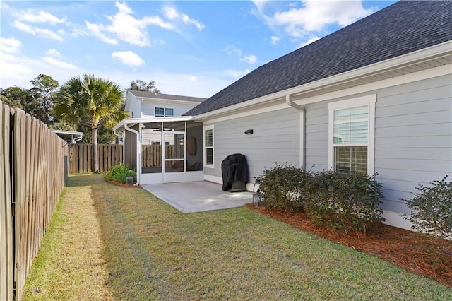 rear view of house with a lawn, a sunroom, and a patio