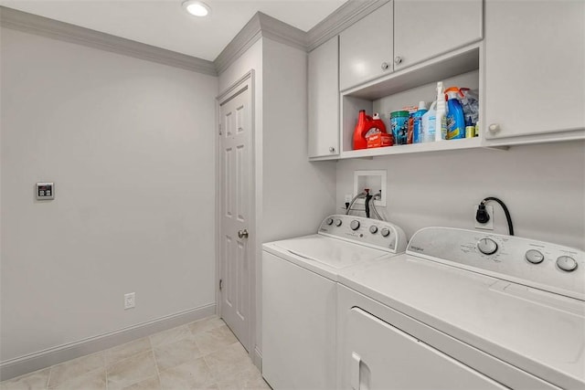 laundry room featuring cabinets, washing machine and dryer, and crown molding