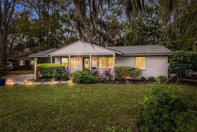 ranch-style house with a porch and a front yard