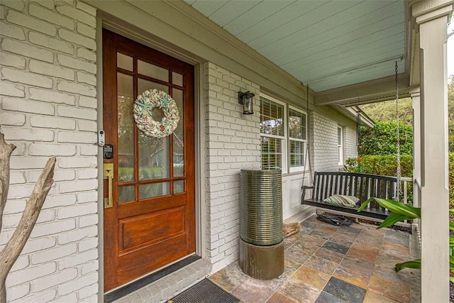 view of exterior entry featuring covered porch