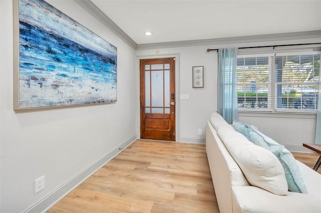 entrance foyer with light hardwood / wood-style floors and crown molding