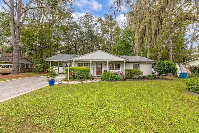 ranch-style home with a front lawn, a porch, and a carport