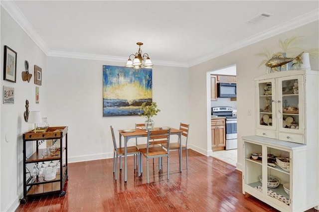 dining area with hardwood / wood-style floors, crown molding, and a chandelier