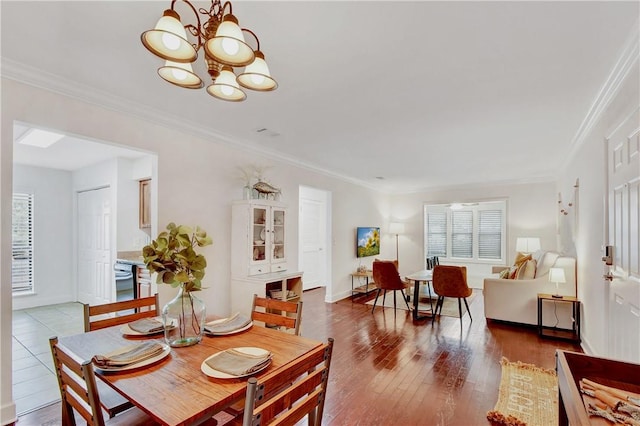 dining room featuring wood-type flooring, ornamental molding, and a notable chandelier