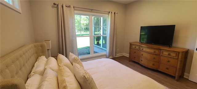 bedroom with baseboards and wood finished floors