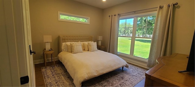 bedroom with dark wood finished floors and baseboards