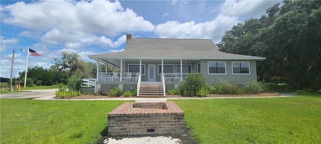 farmhouse inspired home featuring covered porch, a chimney, a front lawn, and roof with shingles