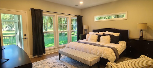 bedroom featuring access to outside and wood finished floors