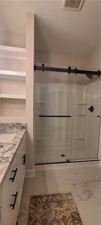 bathroom with a stall shower, marble finish floor, visible vents, and vanity