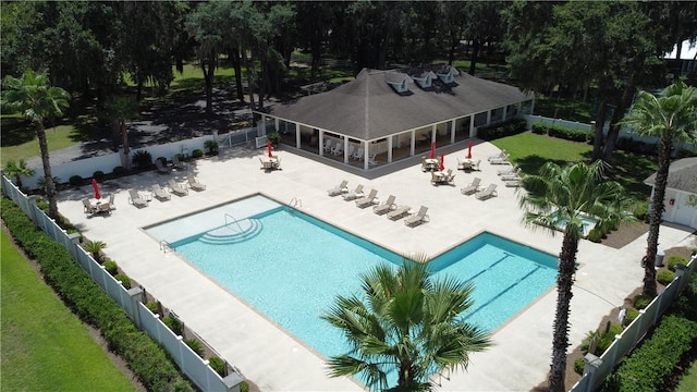 community pool with a patio area, a fenced backyard, and a yard