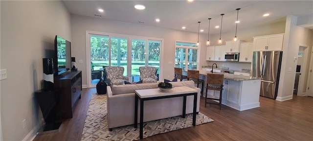 living room with dark wood-type flooring, recessed lighting, and baseboards