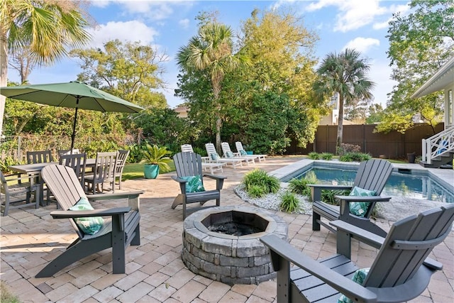 view of patio / terrace featuring a fenced in pool and an outdoor fire pit