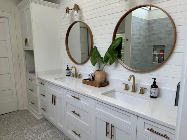 bathroom featuring vanity, a shower, and wood walls