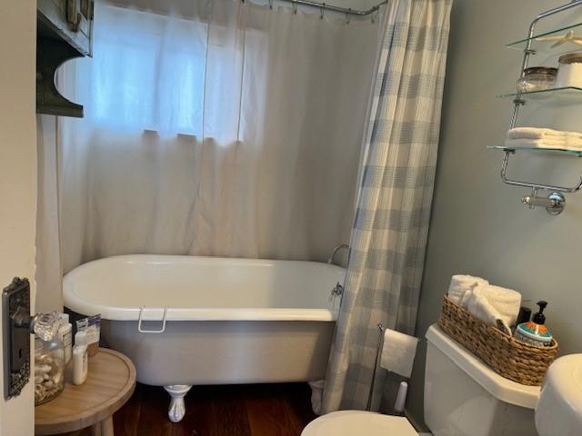 bathroom featuring wood-type flooring and a tub