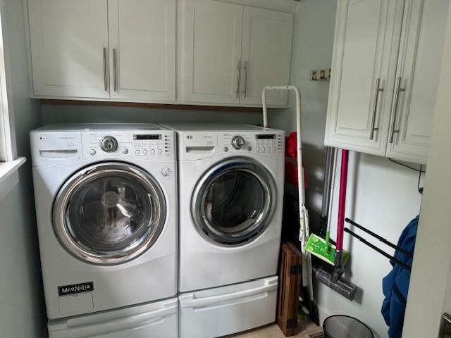 washroom with separate washer and dryer and cabinets