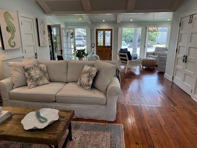 living room featuring coffered ceiling, dark hardwood / wood-style flooring, french doors, and beamed ceiling