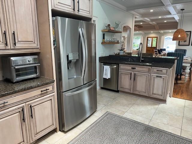 kitchen featuring beam ceiling, sink, light tile patterned flooring, coffered ceiling, and appliances with stainless steel finishes