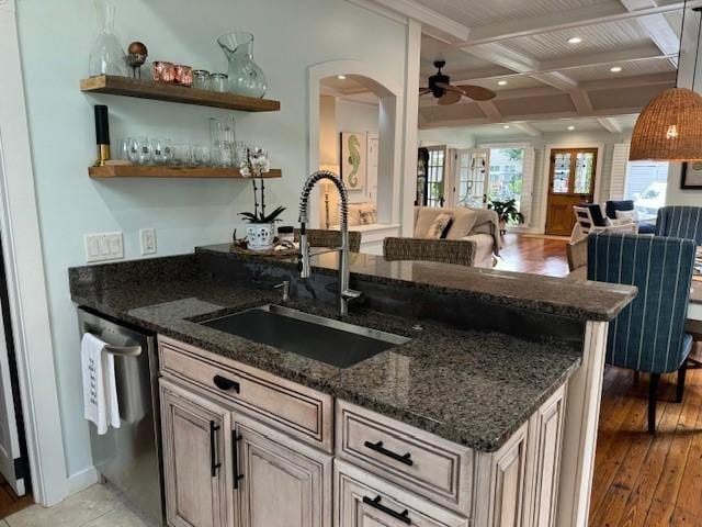 kitchen featuring dishwasher, sink, and dark stone countertops