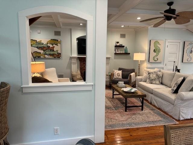 living room featuring beam ceiling, hardwood / wood-style floors, ceiling fan, crown molding, and coffered ceiling