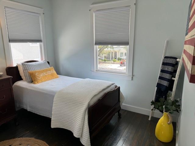 bedroom with dark wood-type flooring and multiple windows