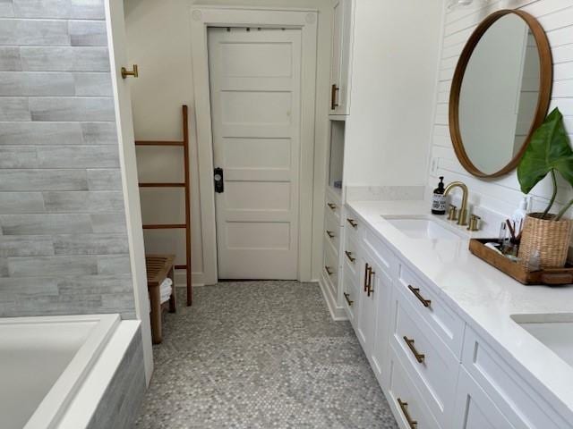 bathroom featuring vanity and a washtub