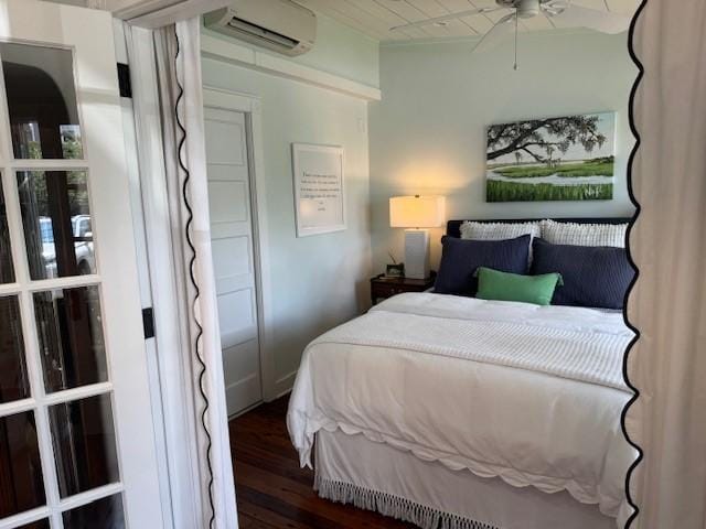 bedroom with an AC wall unit and dark hardwood / wood-style flooring