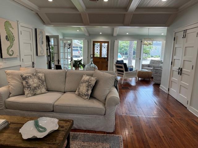 living room featuring dark hardwood / wood-style floors, a wealth of natural light, beam ceiling, and french doors