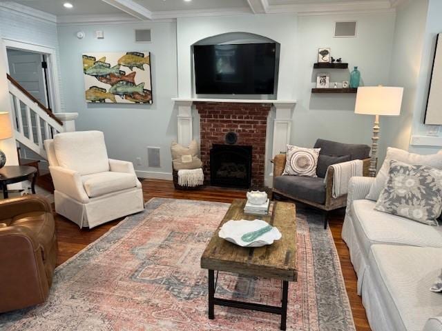 living room with a brick fireplace, beamed ceiling, crown molding, and dark hardwood / wood-style floors