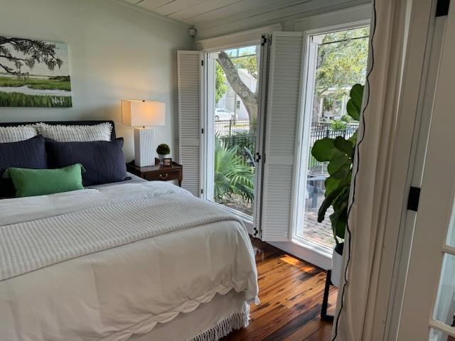 bedroom with access to exterior and dark hardwood / wood-style flooring