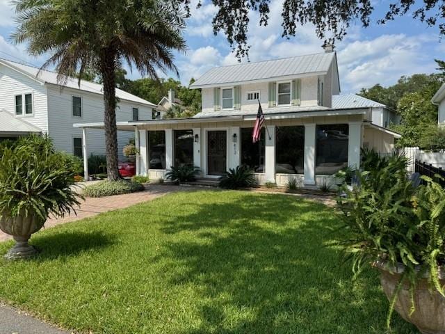 back of house featuring a lawn and a sunroom