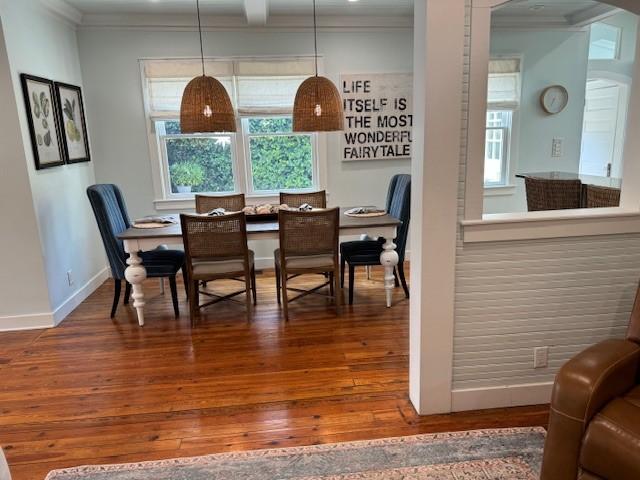 dining space featuring dark hardwood / wood-style floors and ornamental molding