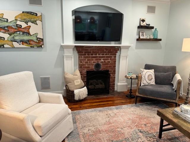 sitting room with crown molding and hardwood / wood-style flooring