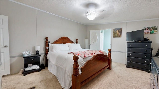 bedroom with ornamental molding, carpet, and a textured ceiling
