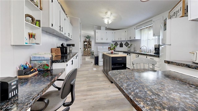kitchen featuring white cabinets, light wood-type flooring, white appliances, and ceiling fan