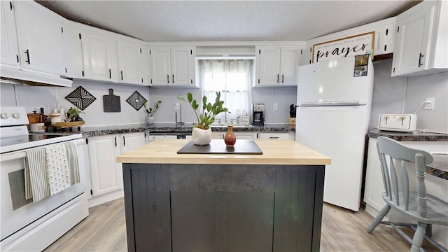 kitchen with white cabinetry, light wood finished floors, under cabinet range hood, and white appliances