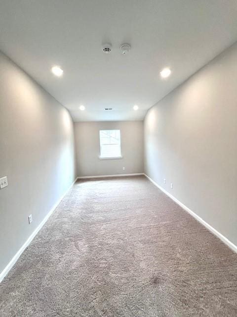 spare room with recessed lighting, carpet, and baseboards