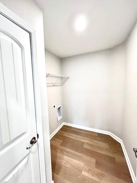 clothes washing area featuring wood finished floors, visible vents, baseboards, laundry area, and electric dryer hookup