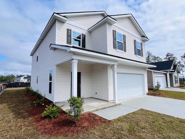 view of front facade with a front lawn, concrete driveway, an attached garage, and fence