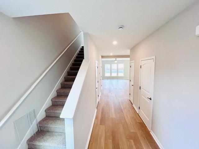 stairs featuring a ceiling fan, recessed lighting, wood finished floors, and visible vents